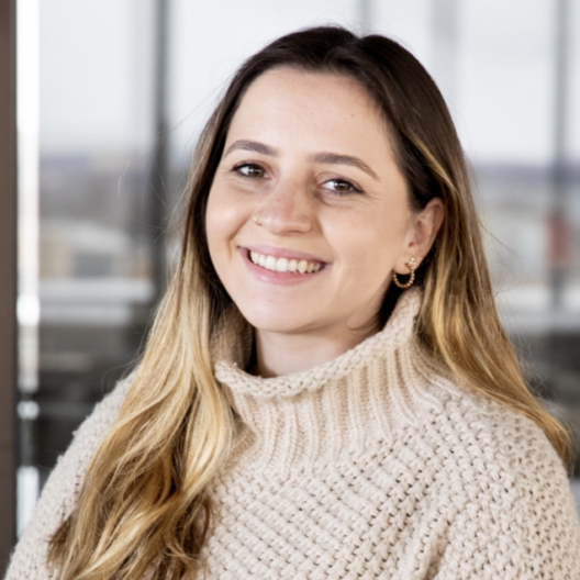Headshot of Paulina Grekov wearing a beige turtleneck sweater and smiling.